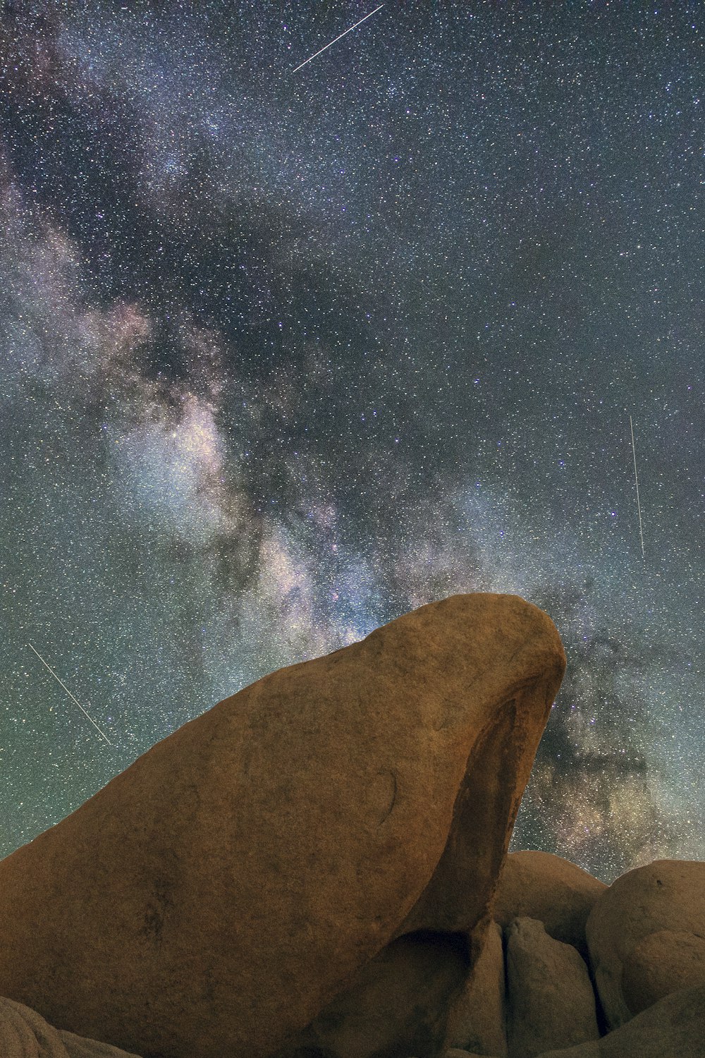 brown rock formation under starry night