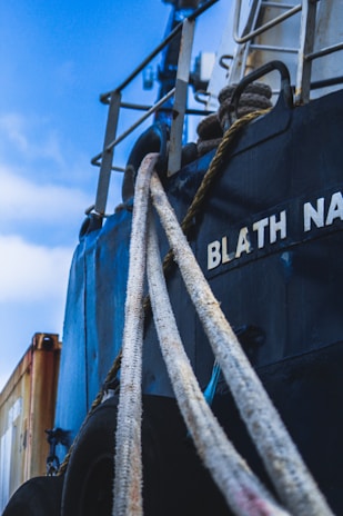 Close-up of a ship captain reviewing shipping documents on the deck with the sea in the background.