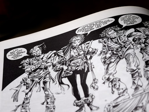 Three intricately drawn characters stand in conversation. Each has unique features and elaborate costumes with a variety of textures. The characters have expressive facial expressions and are engaged in a dialogue with speech bubbles indicating a lively exchange. The artwork is monochromatic, relying heavily on black and white shading.