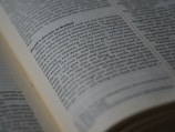 A close-up view of an open book displaying a passage of text in English. The book is arranged in columns, and the text appears to be printed clearly on an off-white page. The focus is on a section of the text, conveying a sense of depth and highlighting readability.