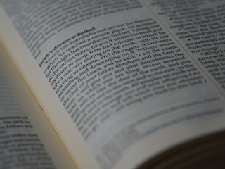 A close-up view of an open book displaying a passage of text in English. The book is arranged in columns, and the text appears to be printed clearly on an off-white page. The focus is on a section of the text, conveying a sense of depth and highlighting readability.