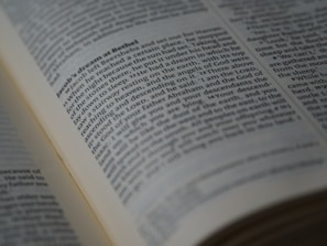 A close-up view of an open book displaying a passage of text in English. The book is arranged in columns, and the text appears to be printed clearly on an off-white page. The focus is on a section of the text, conveying a sense of depth and highlighting readability.