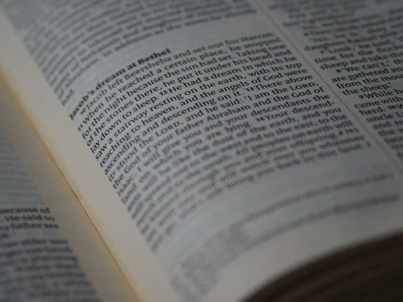 A close-up view of an open book displaying a passage of text in English. The book is arranged in columns, and the text appears to be printed clearly on an off-white page. The focus is on a section of the text, conveying a sense of depth and highlighting readability.