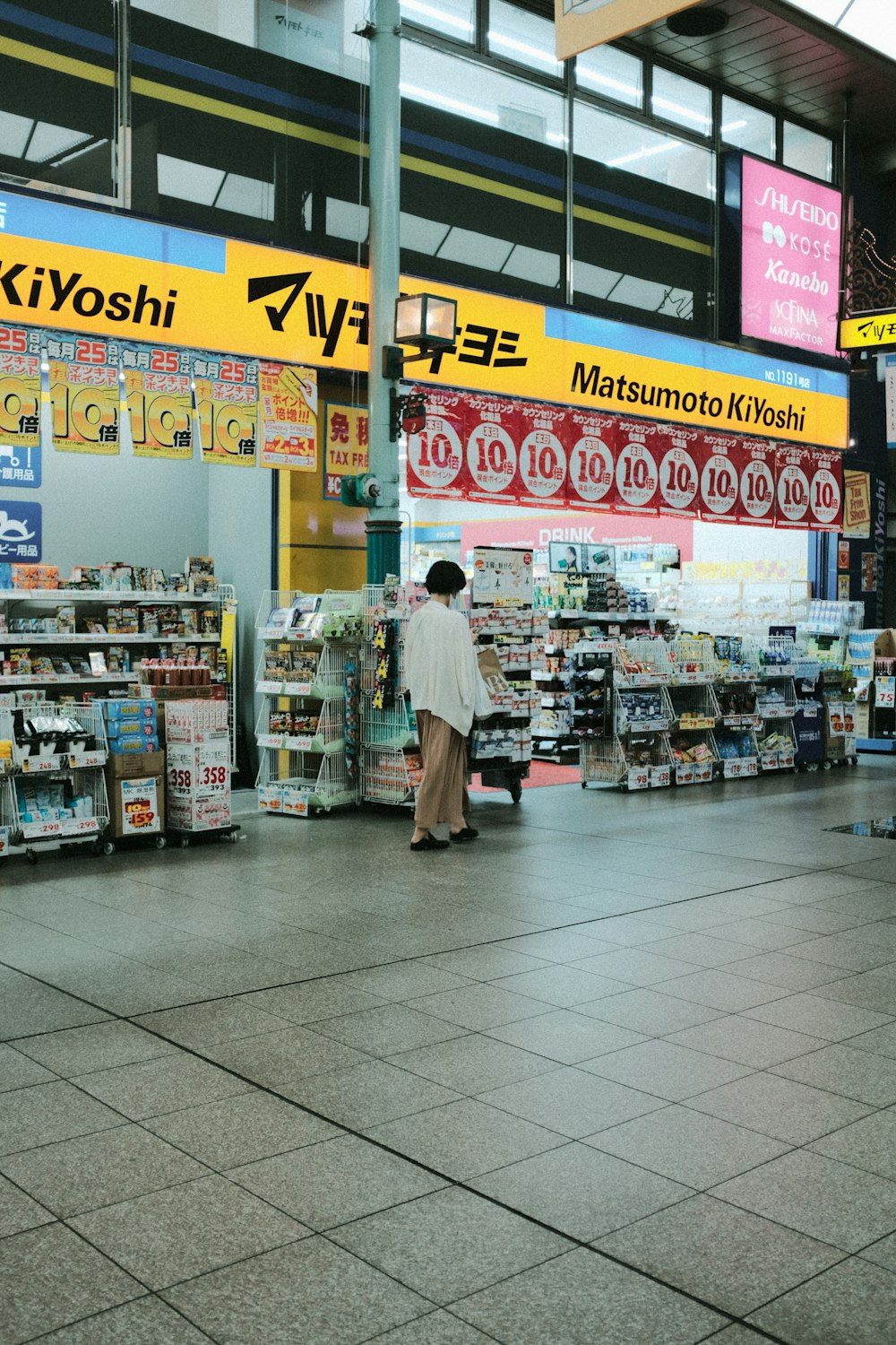 woman in white and black dress standing in front of store