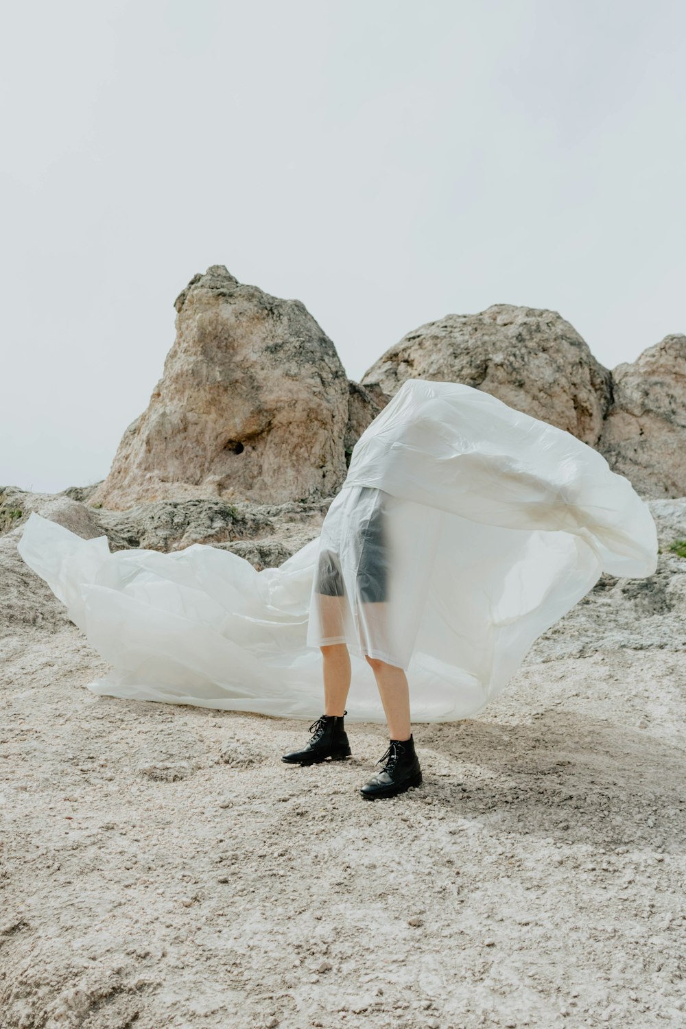 person in black leather boots standing on white plastic bag