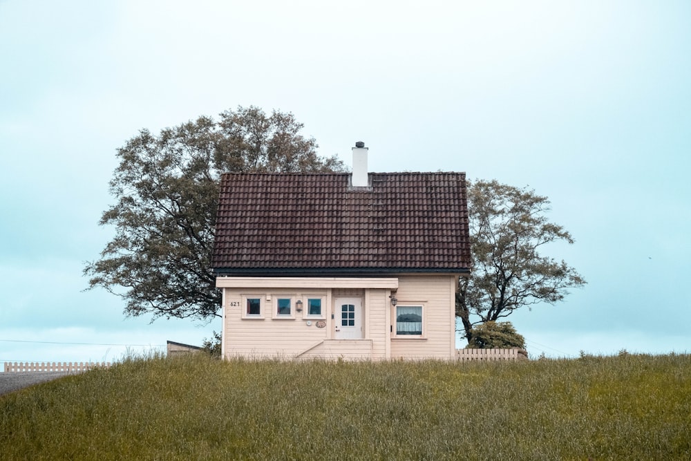 Maison en béton blanc et noir près d’arbres verts sous un ciel blanc pendant la journée