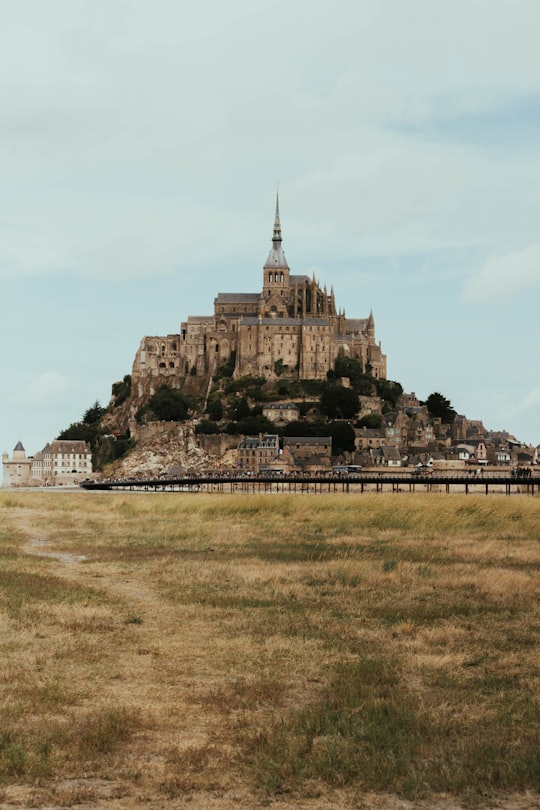 brown concrete building on green grass field during daytime in Mont Saint-Michel France