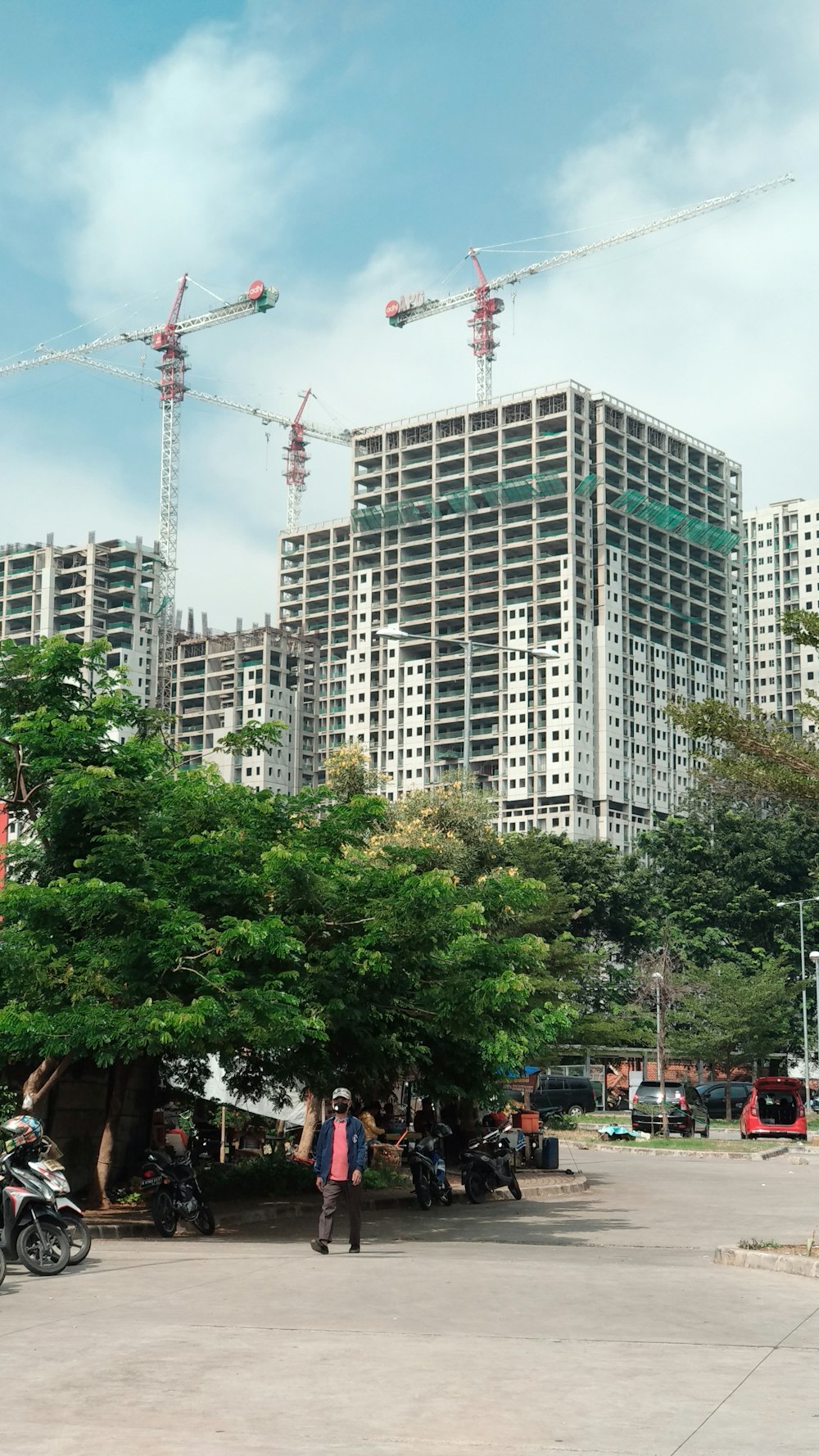 people walking on street near green trees and high rise buildings during daytime