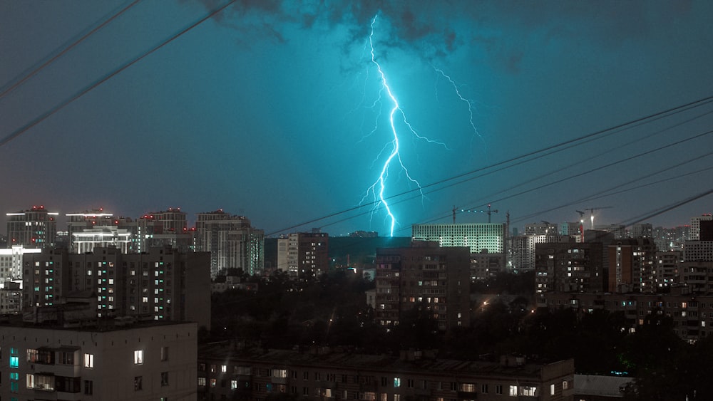 a lightning bolt is seen over a city at night