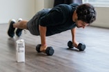 A man doing push-ups on a wooden floor at home