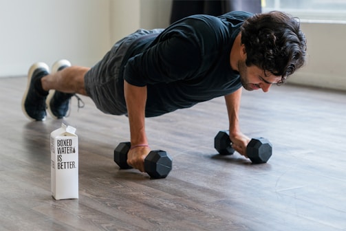 A man doing push-ups on a wooden floor at home