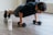Image of a fit man doing push-ups with Power Supps products visible nearby.
