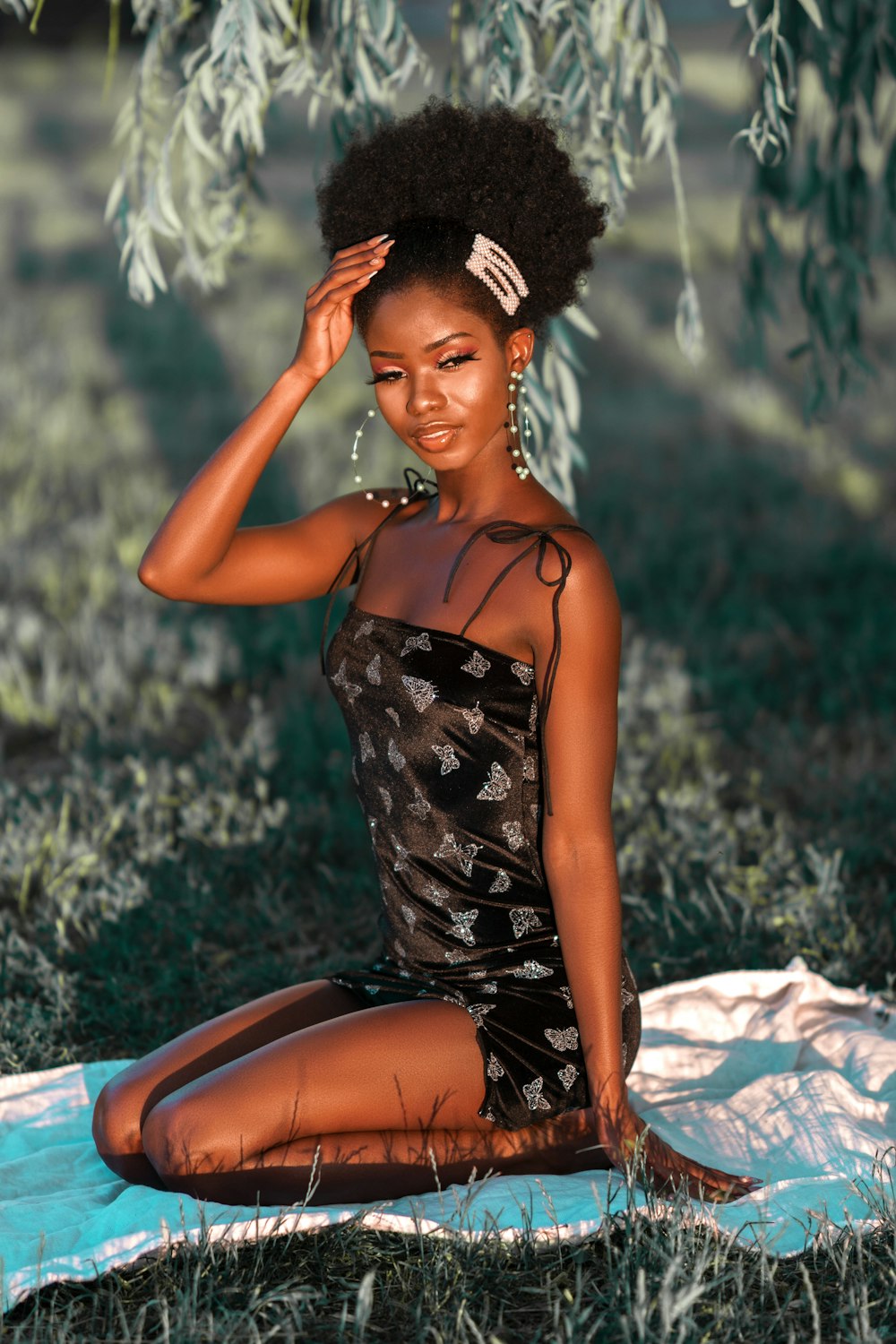 woman in black and white floral spaghetti strap dress sitting on white textile