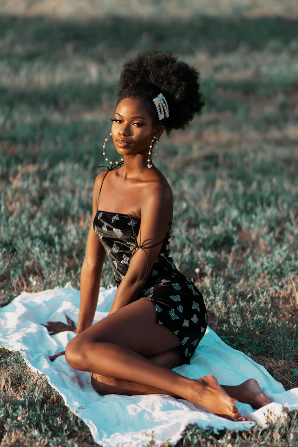 Mulher de vestido estampado sentada sobre uma toalha ao ar livre