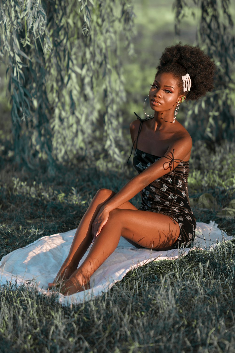 woman in black and white polka dot dress sitting on white textile