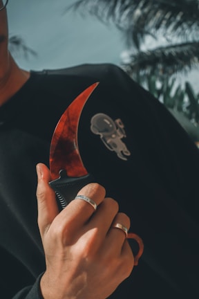 Close-up of Freddy Krueger's iconic glove with razor-sharp blades glinting in dim light.