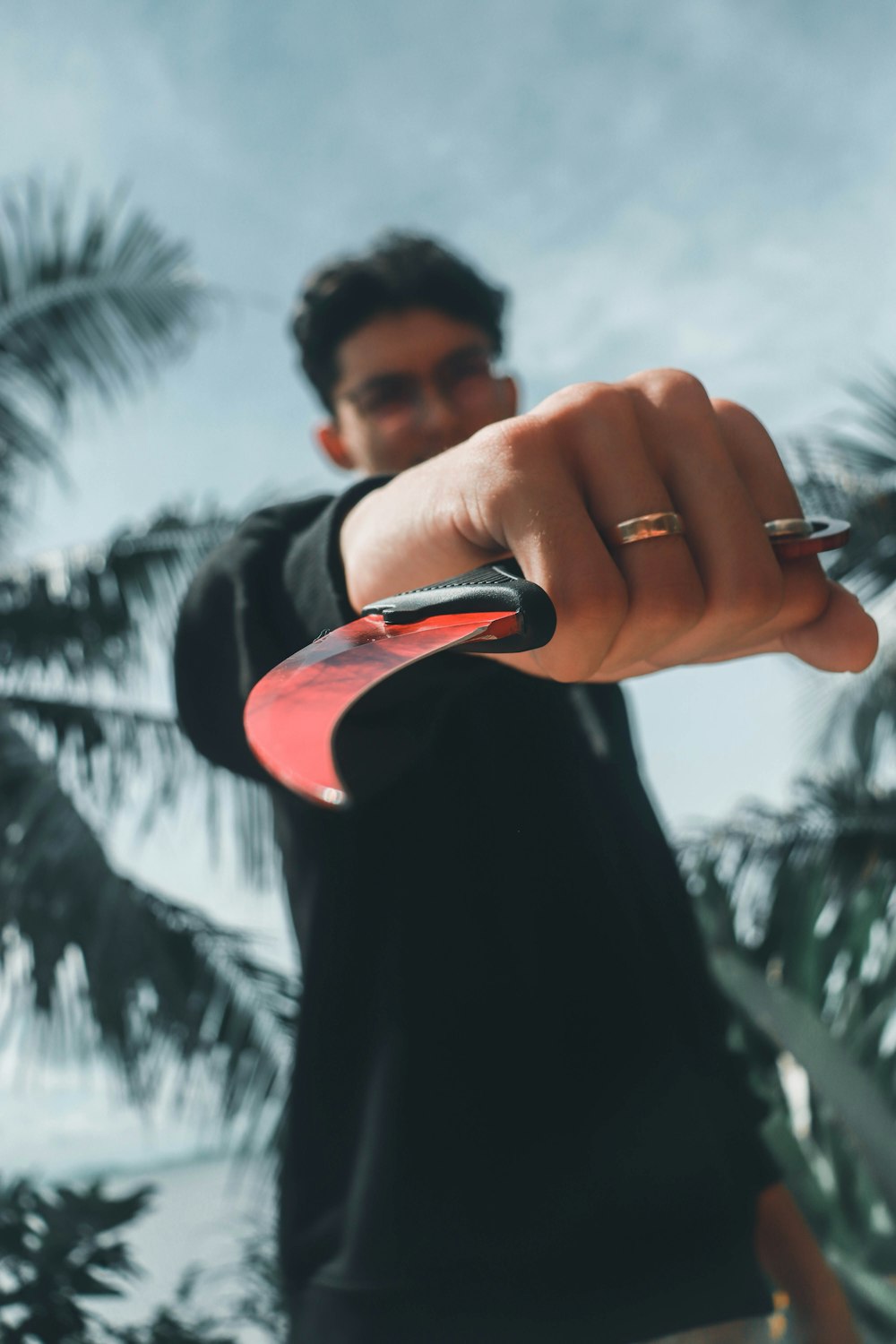 hombre con camisa negra sosteniendo un teléfono inteligente rojo y negro