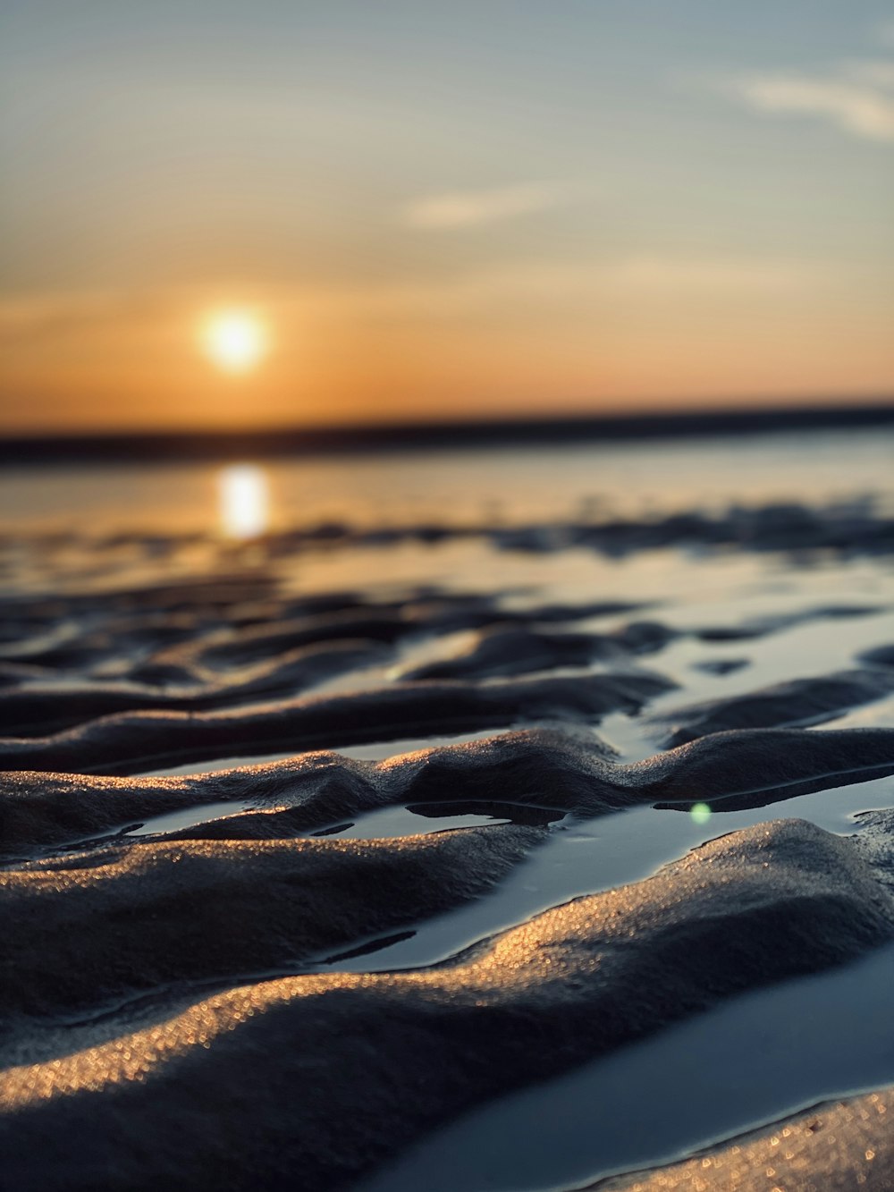 water on brown sand during sunset