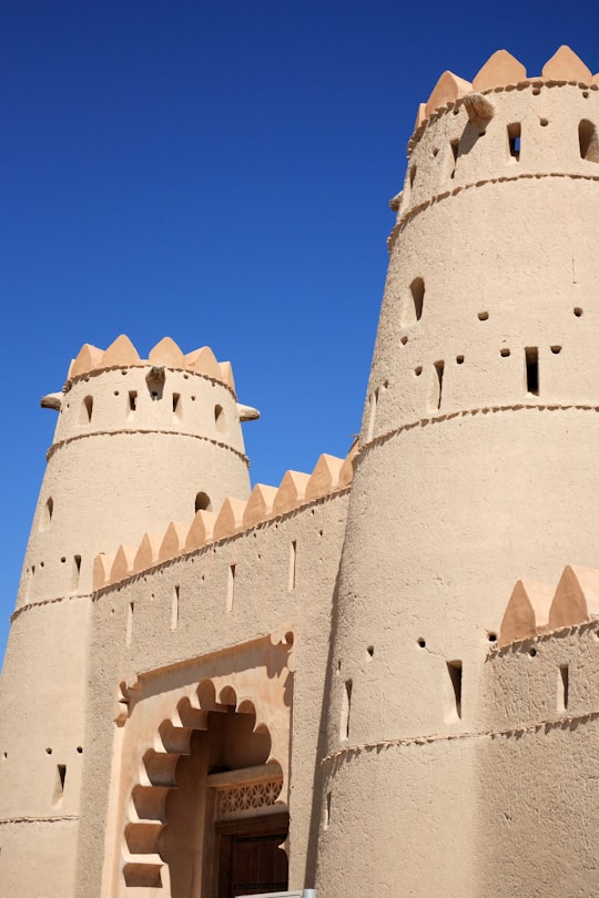 gray concrete castle under blue sky during daytime in Al Jahili Fort United Arab Emirates