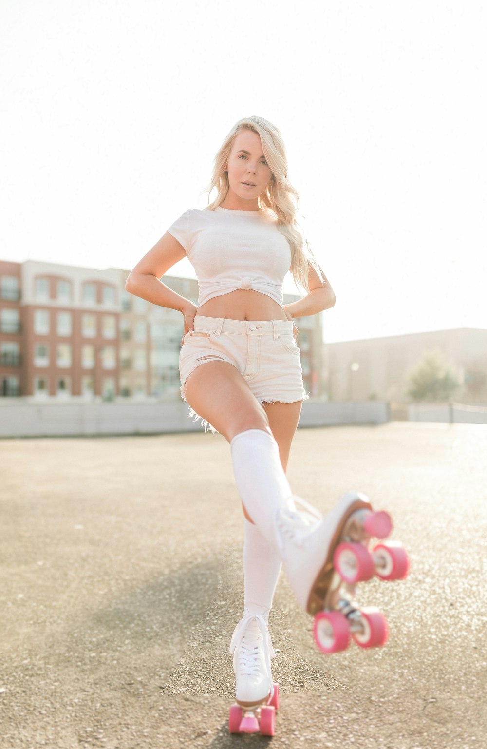 woman in white tank top and white shorts standing on gray concrete floor during daytime