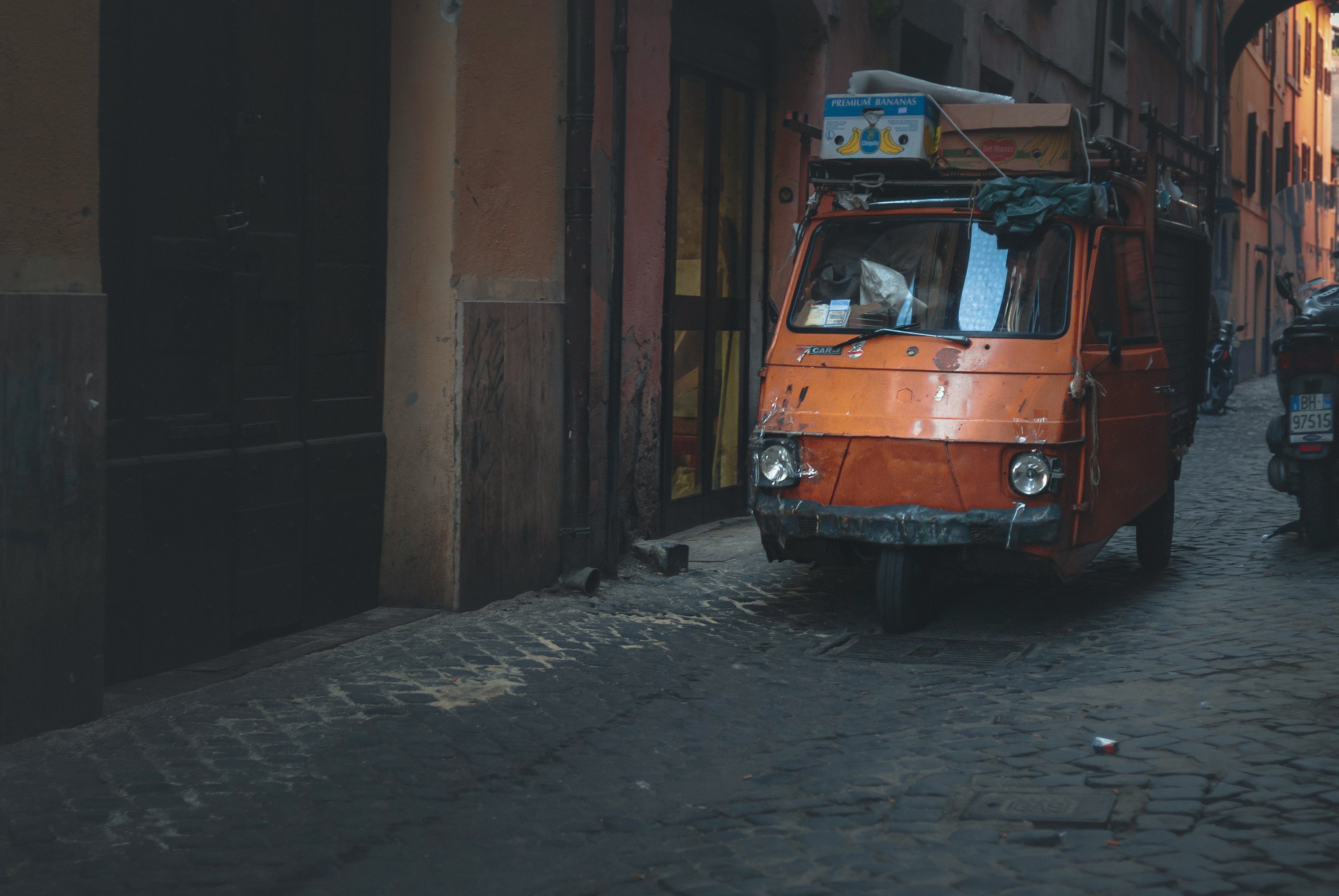 orange volkswagen t-2 parked beside brown concrete building during daytime