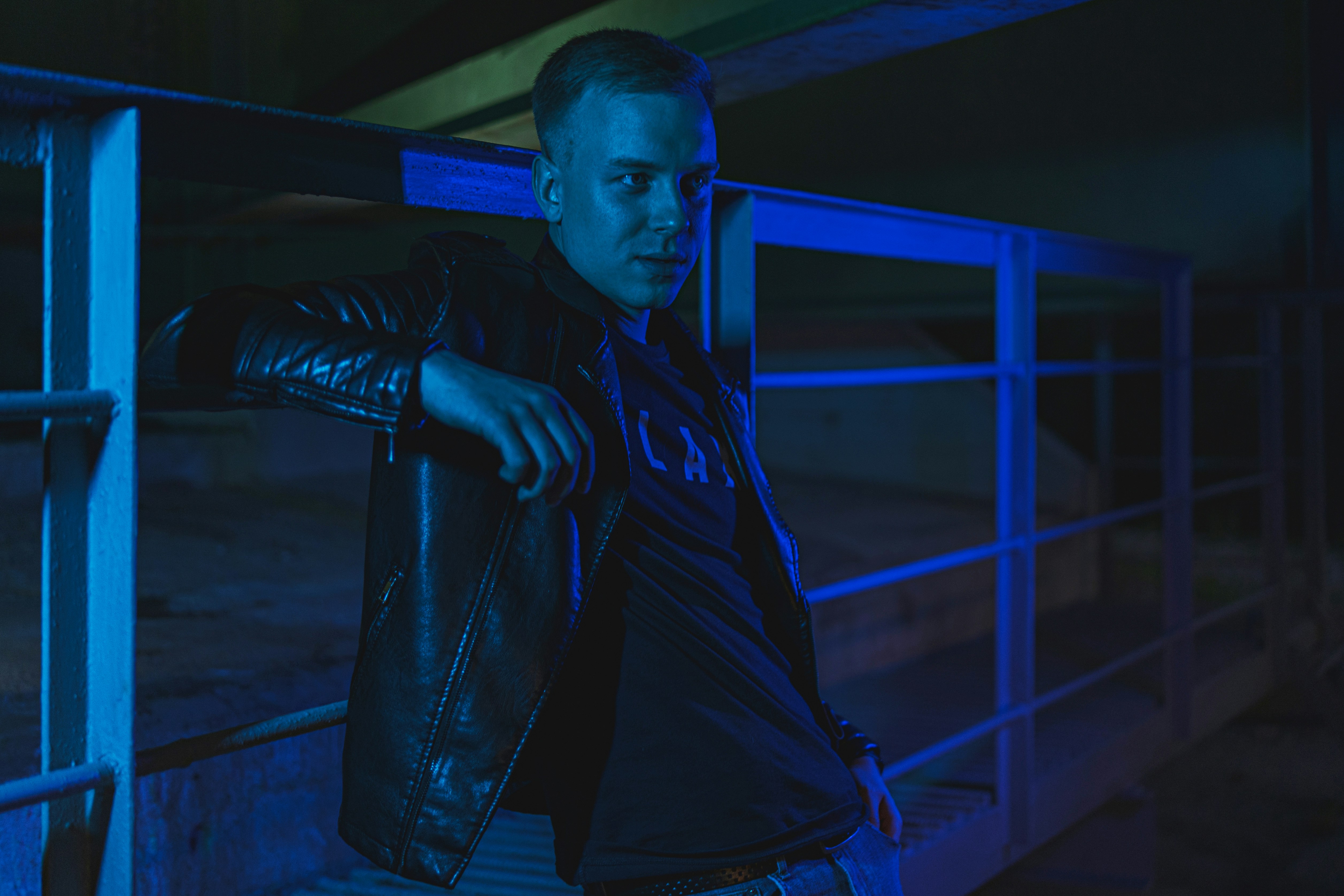 man in blue adidas jersey shirt and black leather jacket