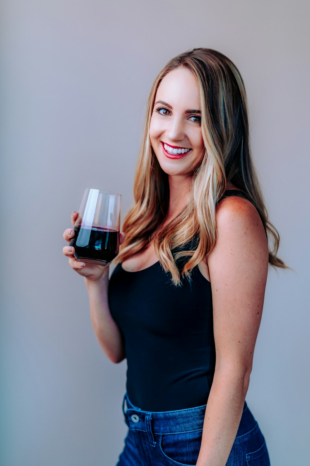 woman in black tank top holding wine glass