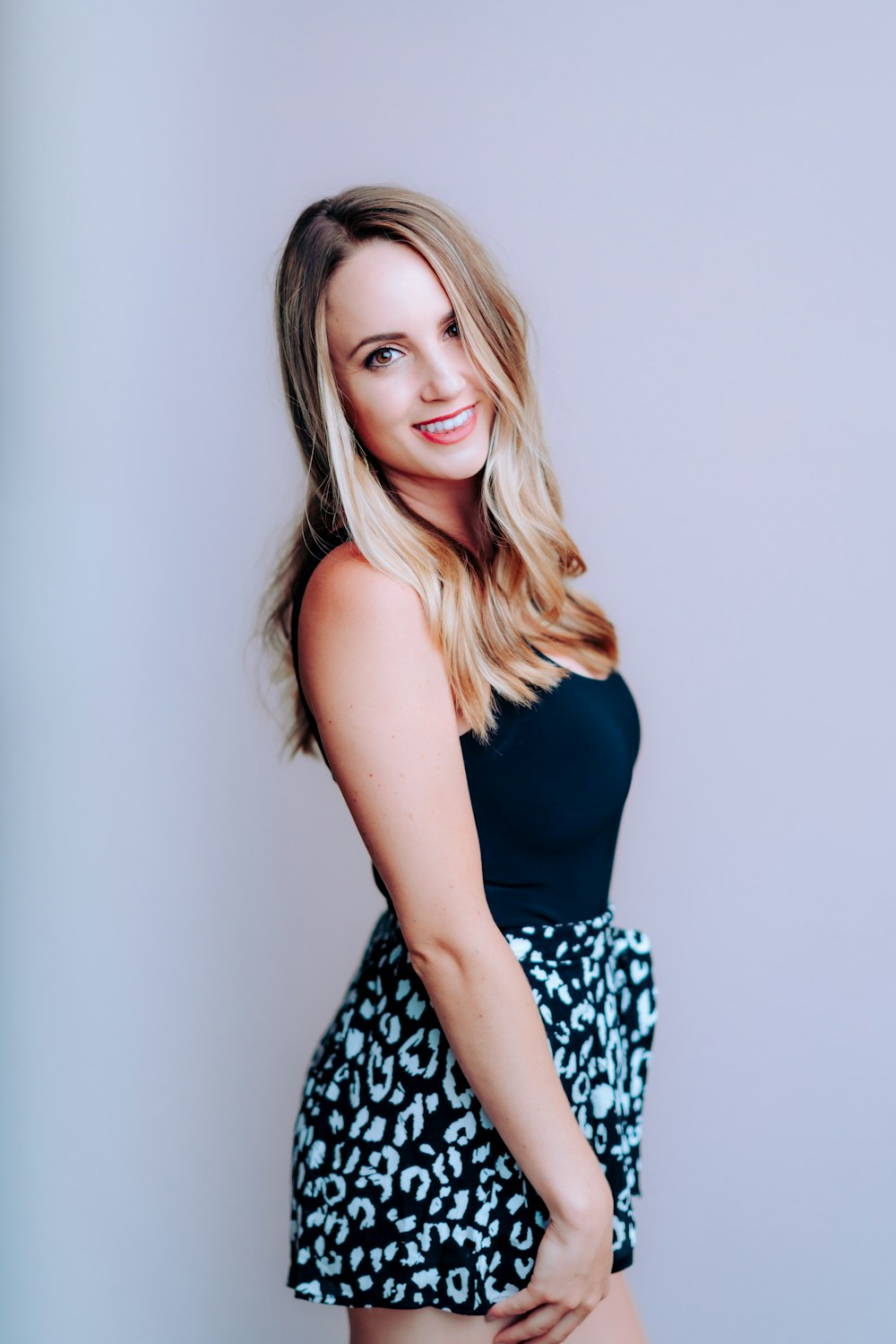 woman in black tank top and white and black floral skirt