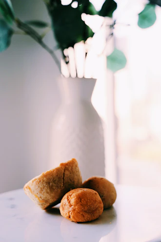 Close-up of bite-sized gourmet pastries arranged on a marble surface with soft natural light.