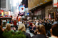 An energetic megastar leading a lively guerrilla marketing activation on a busy city street.