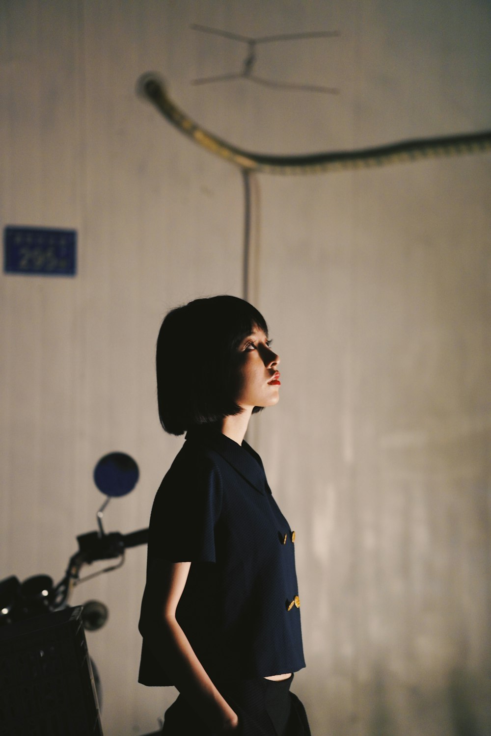 woman in black shirt standing near white wall