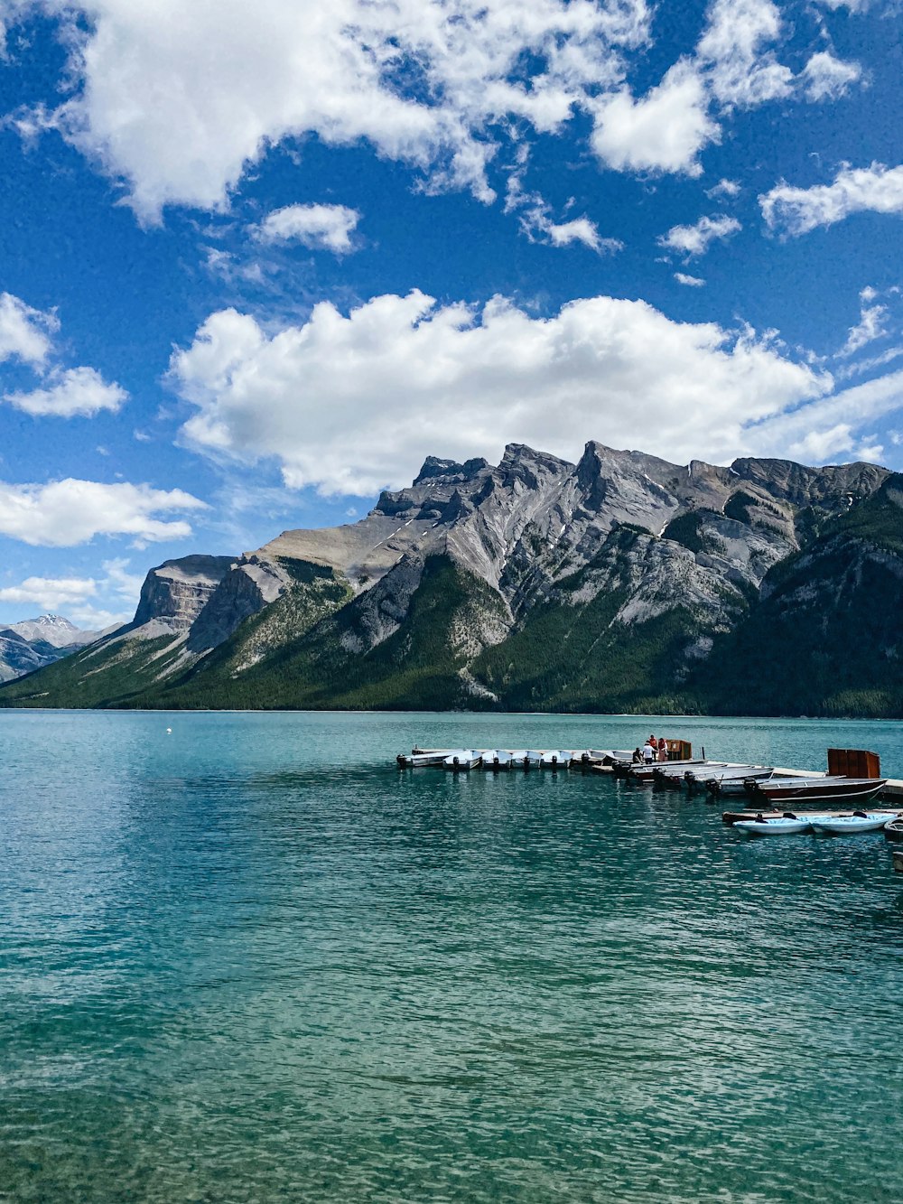 white boat on sea near mountain under blue sky during daytime