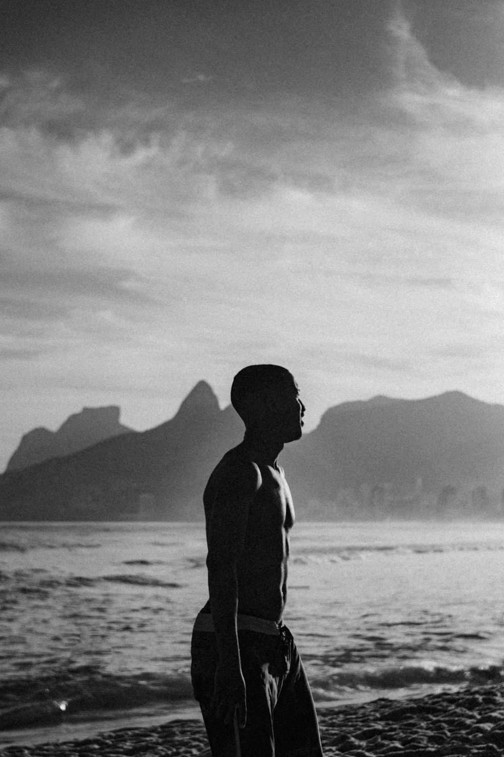 man in black jacket standing on seashore during daytime