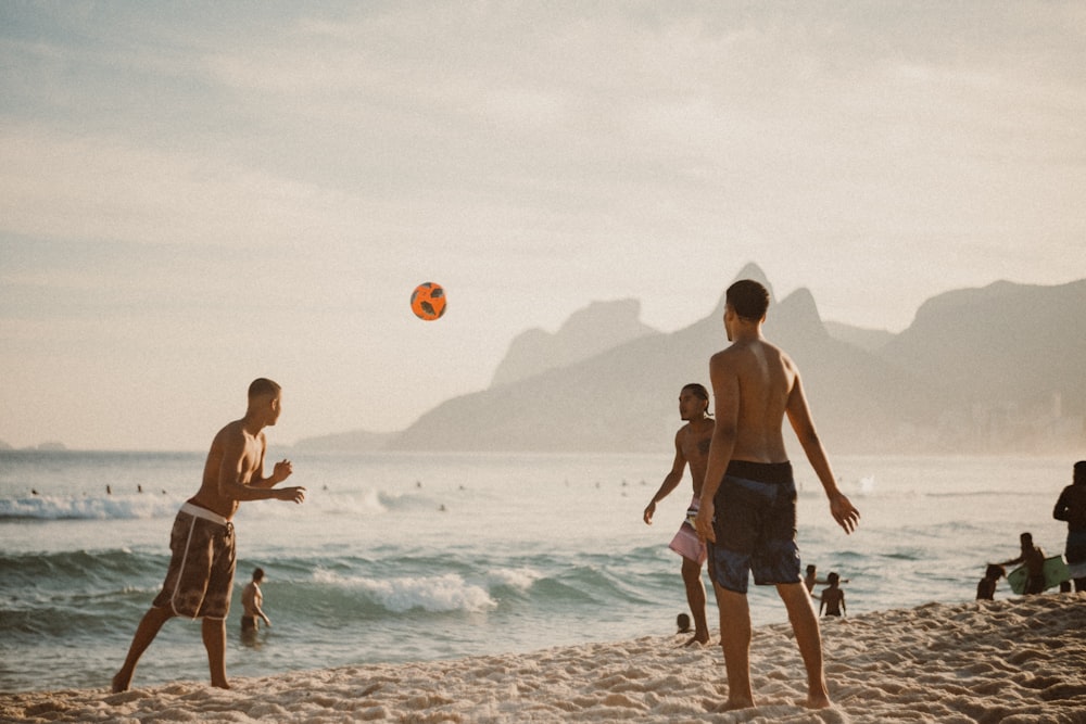 uomo in pantaloncini neri che si tiene per mano con la donna in canotta bianca sulla spiaggia durante il giorno