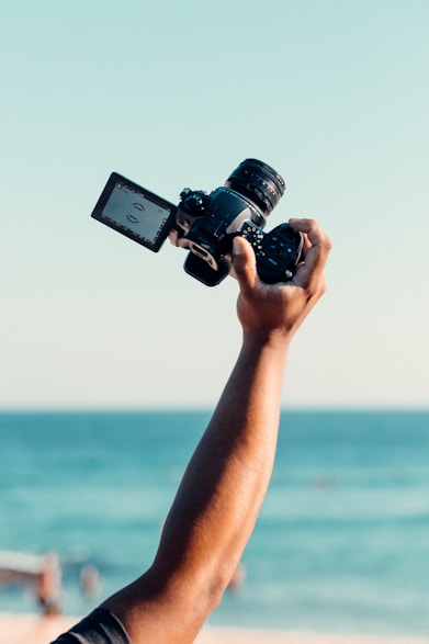 person holding black dslr camera