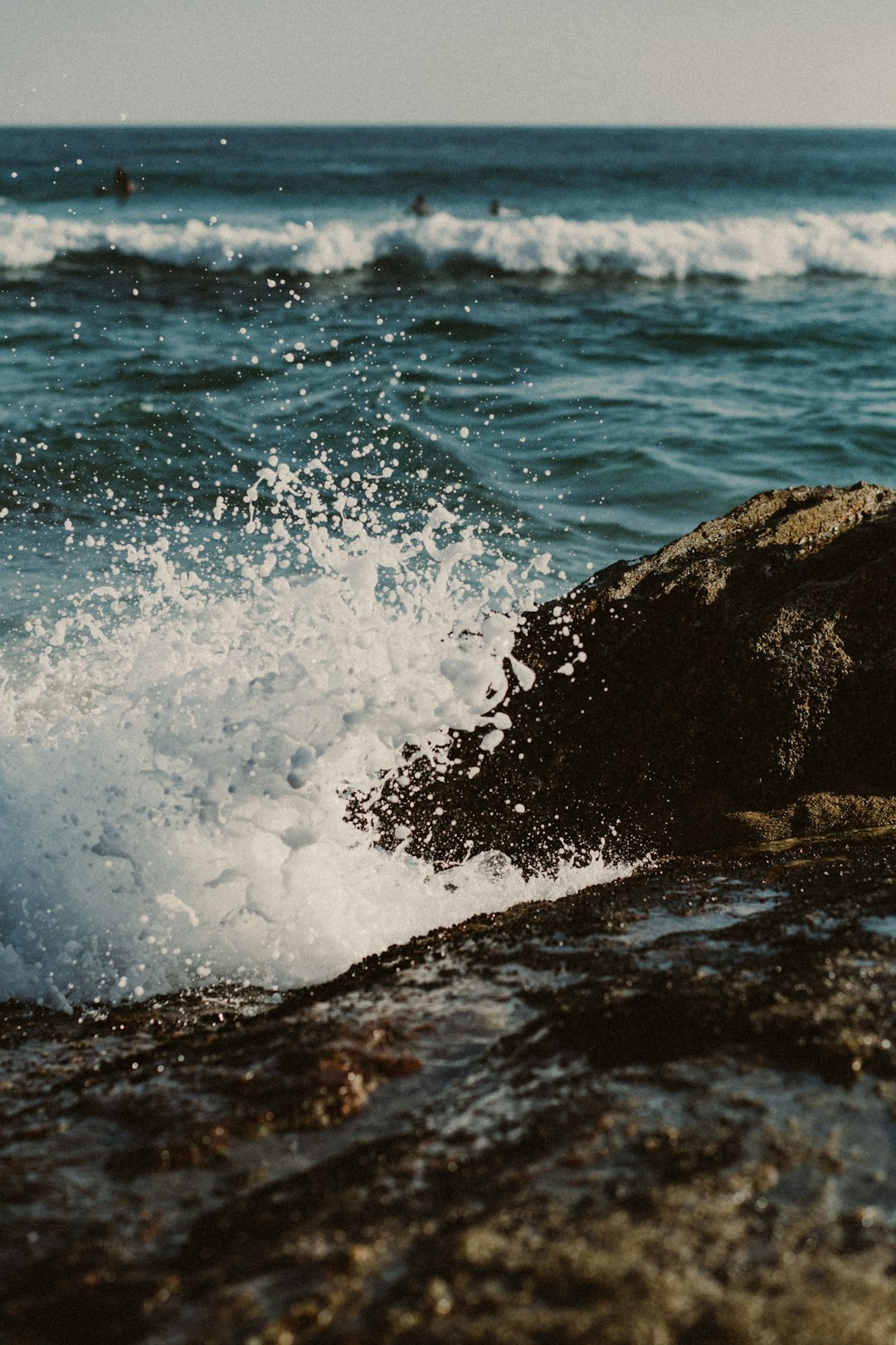 ocean waves crashing on black rock