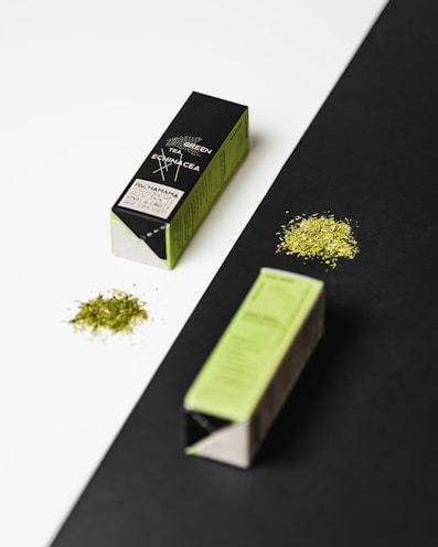Green tea leaves and metabolism capsules artfully arranged on a wooden table.