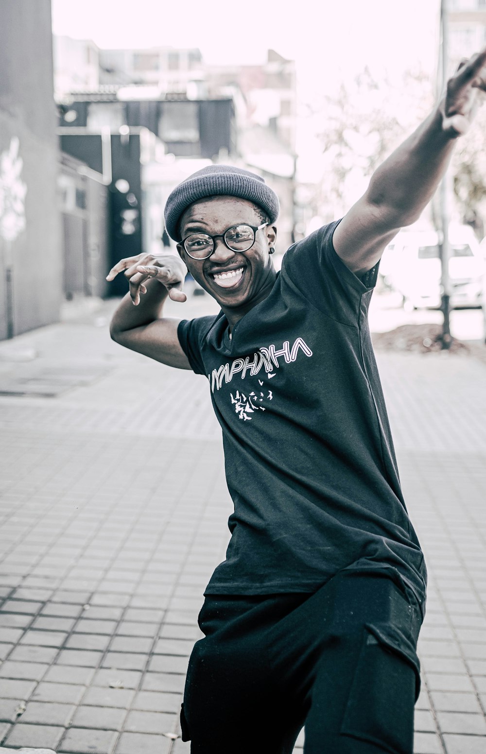 homme en noir t-shirt à col rond et pantalon noir portant une casquette en tricot noir