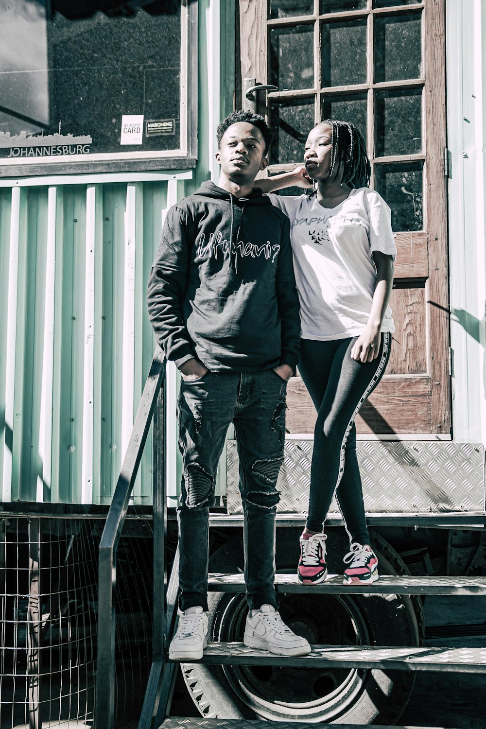 man in black and white hoodie standing beside woman in gray jacket