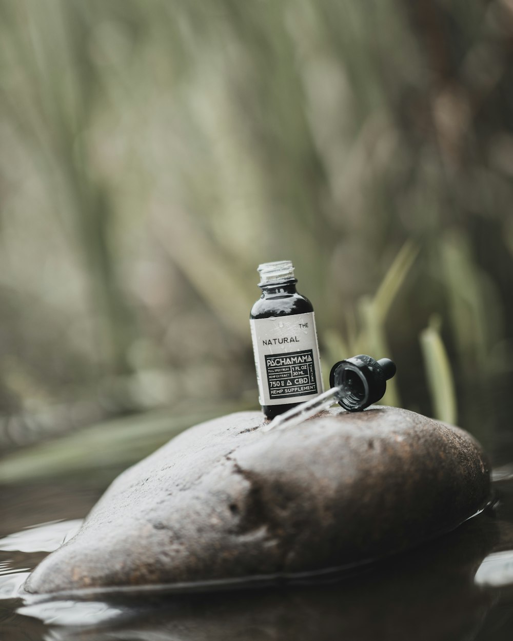 black and white labeled bottle on brown rock