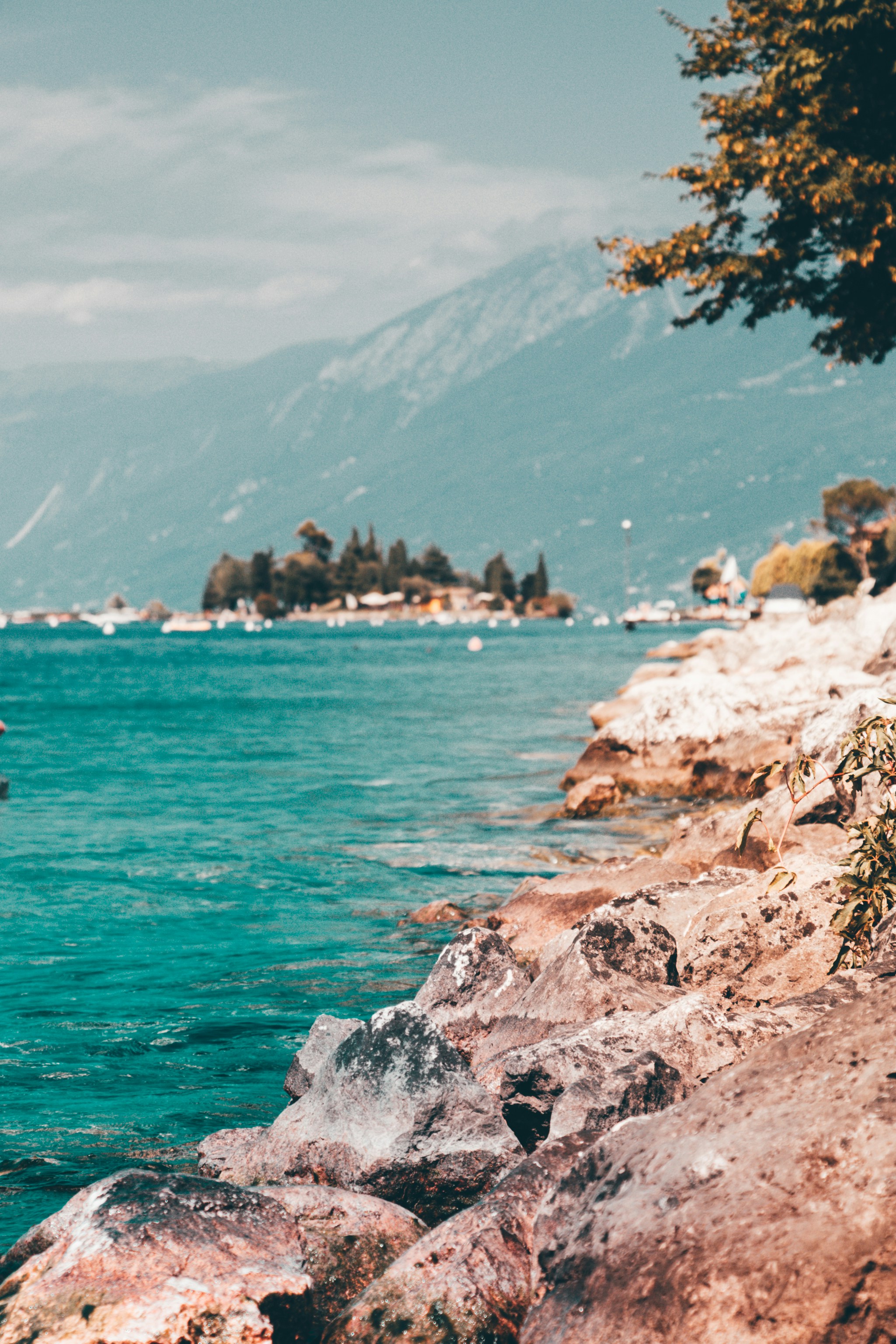 遠くに青い海と山がある茶色の岩礁海岸の写真 Unsplashで見つける青いの無料写真