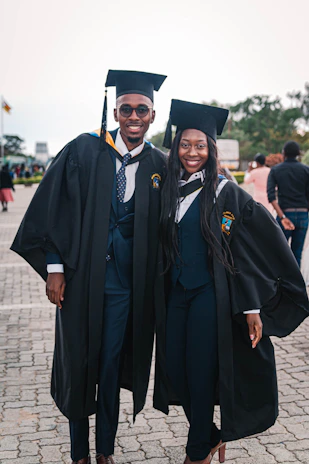 Graduation ceremony with students in caps and gowns celebrating their achievement outdoors.