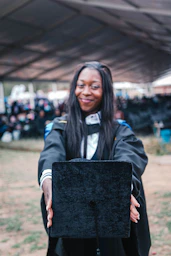 woman in black and white jacket holding black box