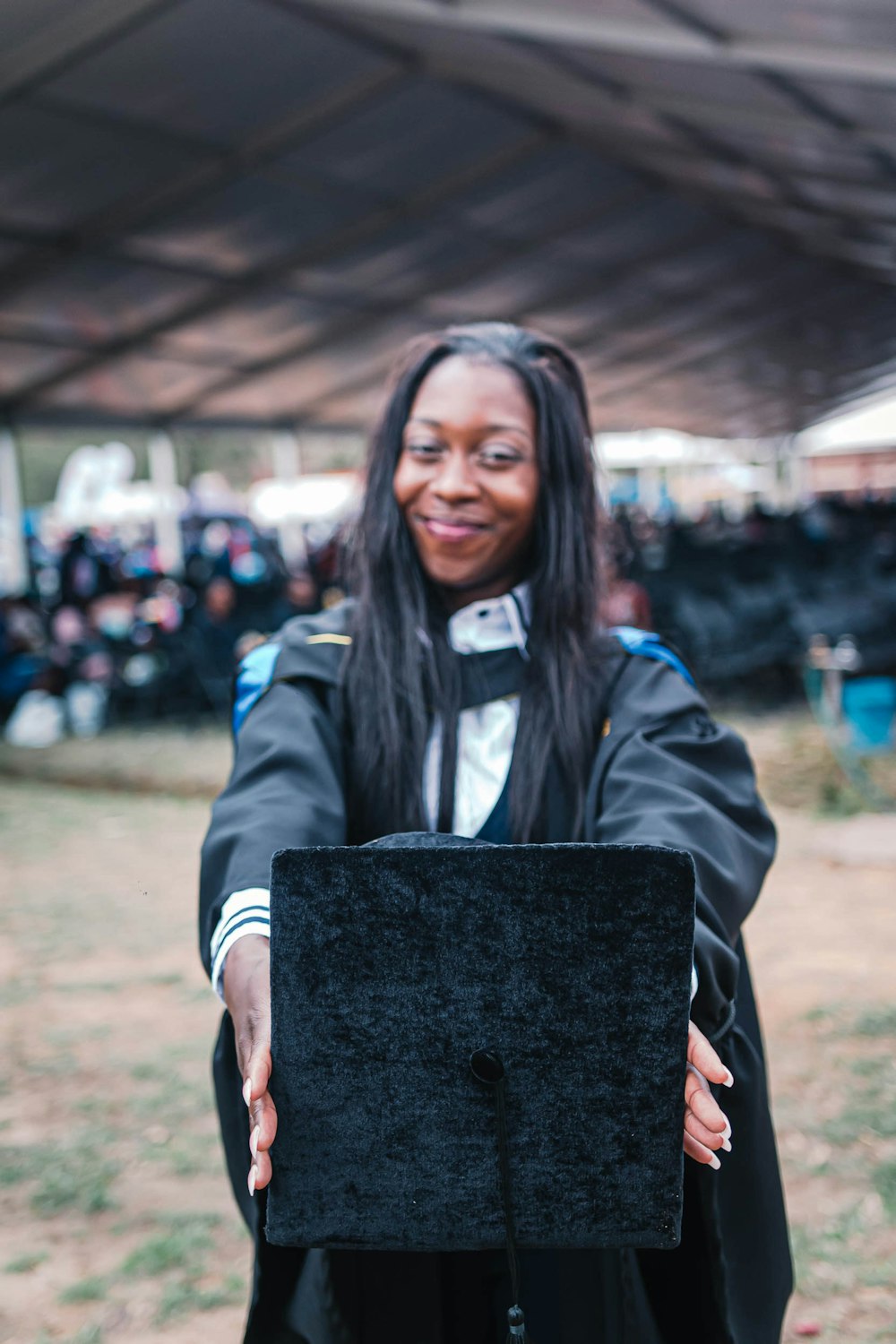 woman in black and white jacket holding black box