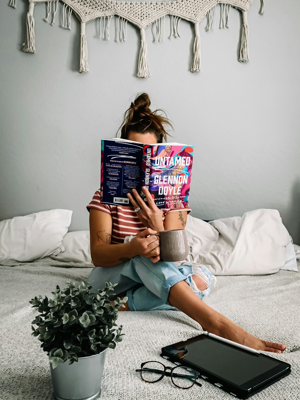 mujer en camiseta sin mangas gris leyendo libro