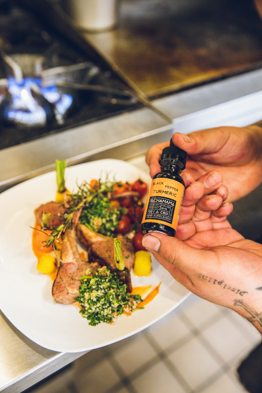 person holding black and yellow labeled bottle