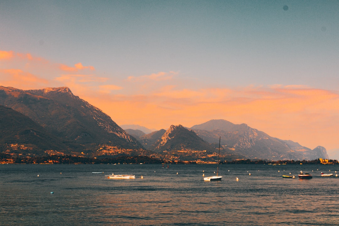 boat on sea near mountain during sunset