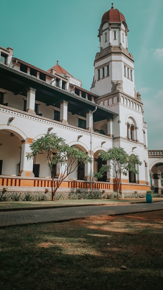 white concrete building near green trees during daytime in Lawang Sewu Indonesia