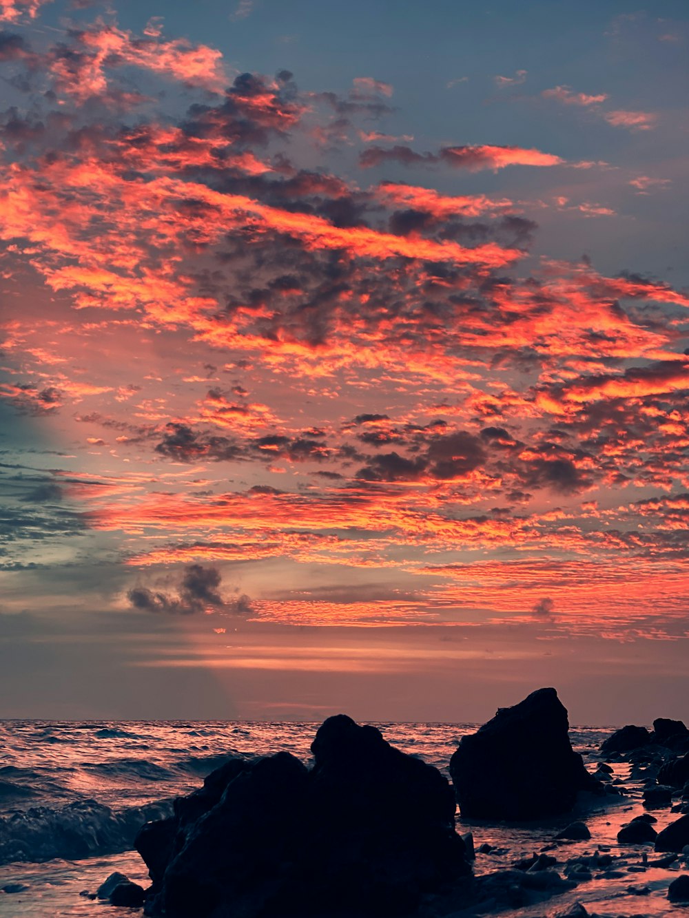 Silueta de la formación rocosa bajo el cielo nublado durante la puesta del sol