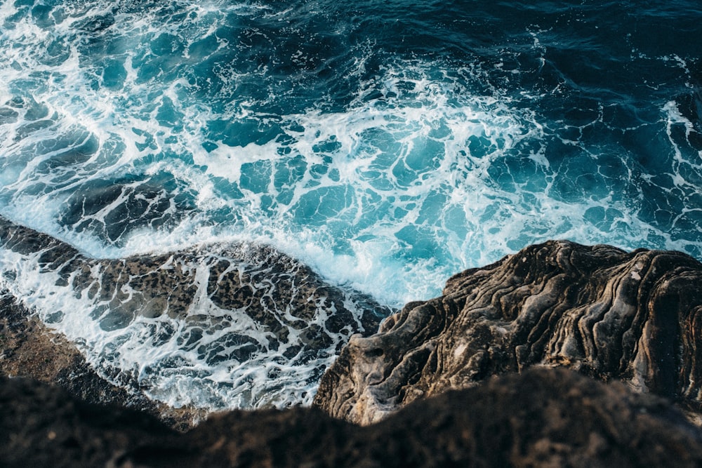 ocean waves crashing on rocky shore during daytime